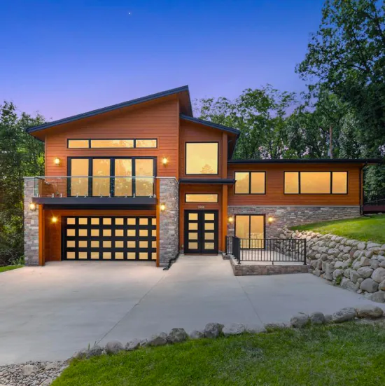 A modern home with lights on during the evening.