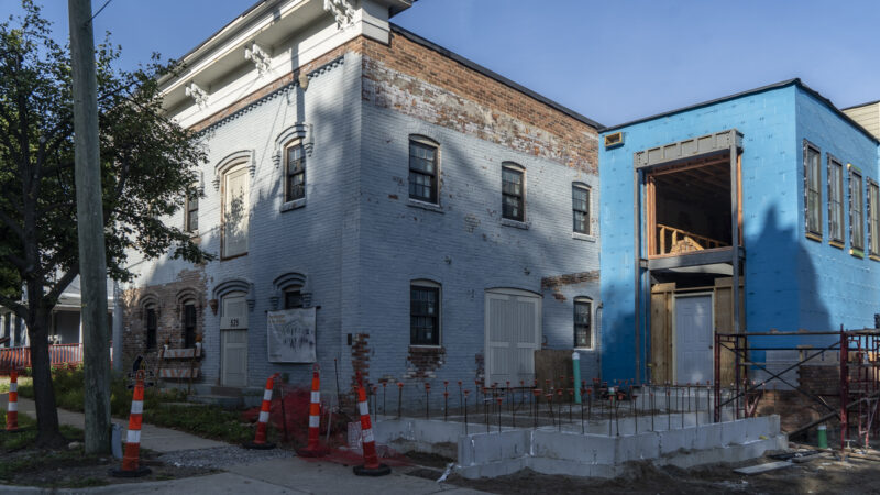 Historic brick building at 525 Detroit Street in Ann Arbor beside a new addition under construction