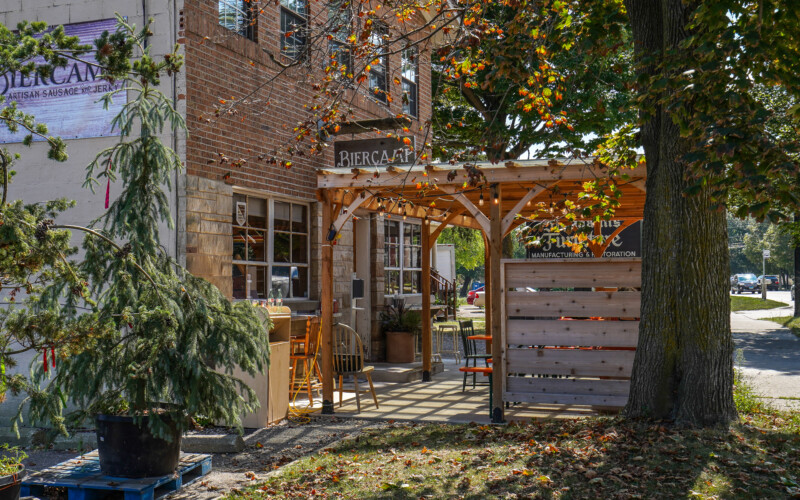 Craft beer and homemade cured meats await you at Biercamp. A wooden patio canopy outside the front of Biercamp.