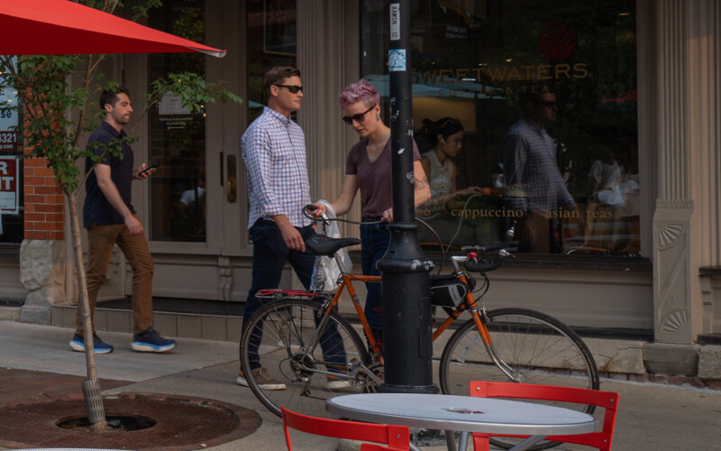 Get an espresso or tea at the Sweetwaters Coffee and Tea. A biker parking their bike outside the Sweetwaters Coffee and Tea on Washington St.