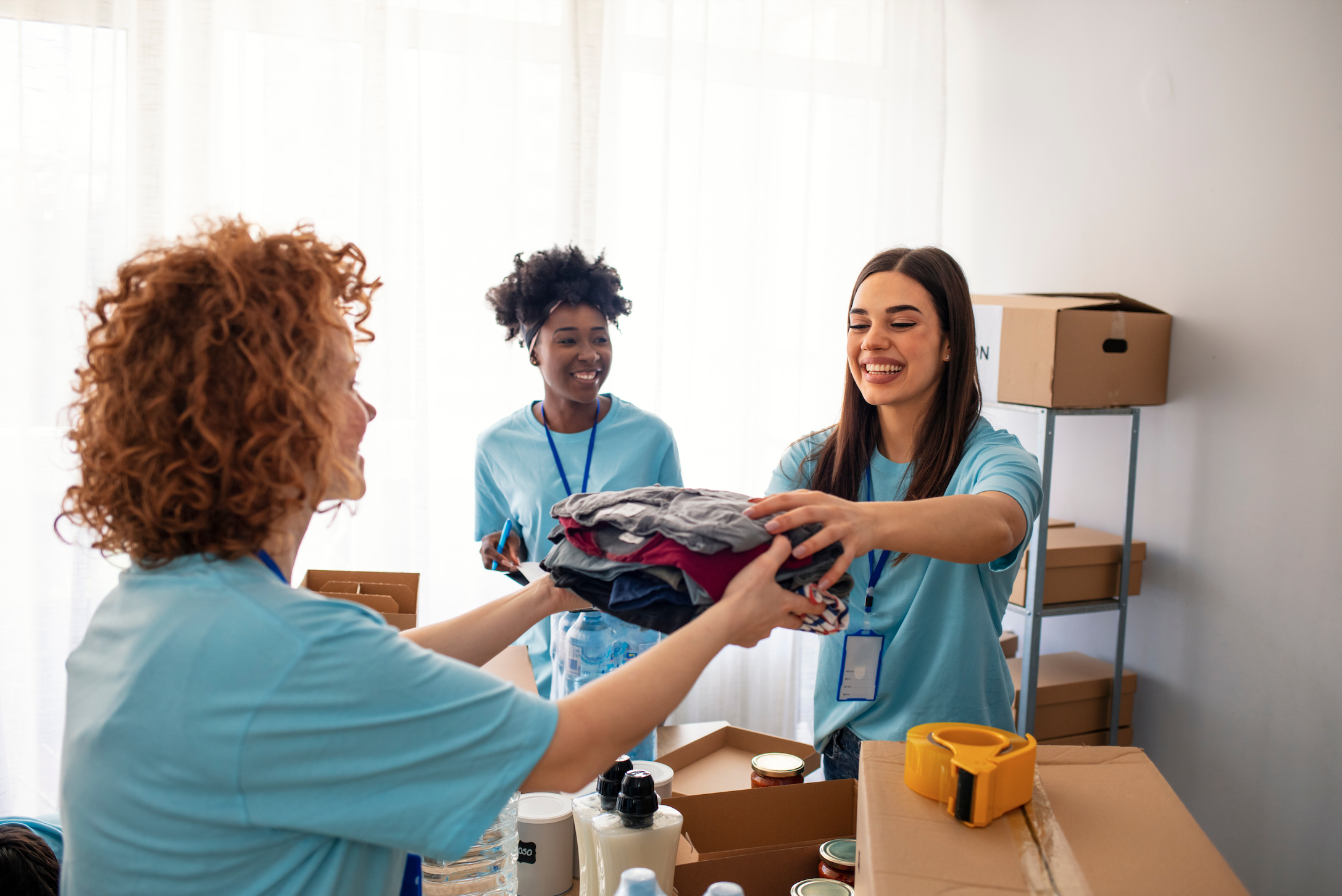 two young women donate clothing to a charity.
