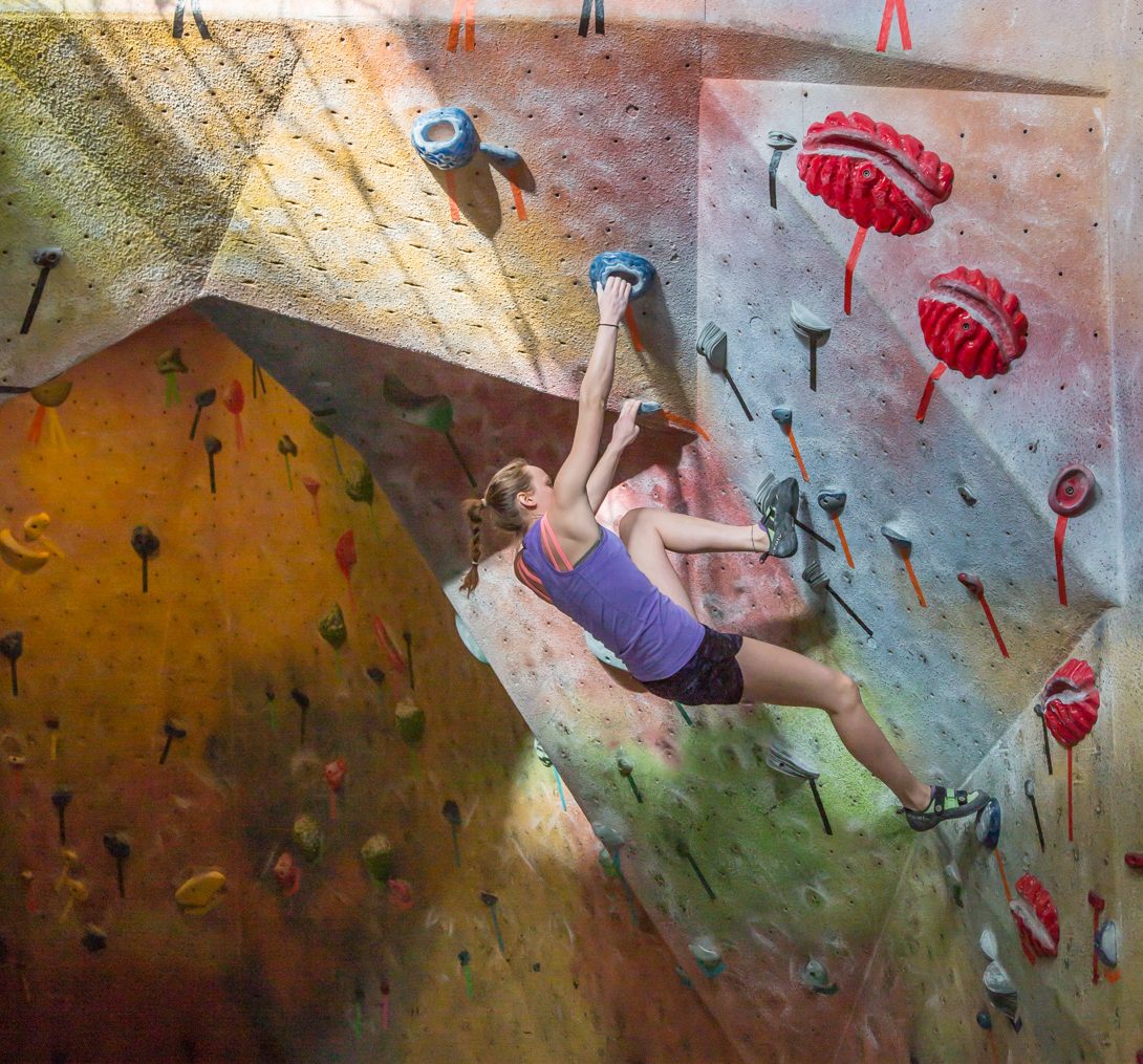 woman climbing wall at Planet Rock Climbing Gym. 