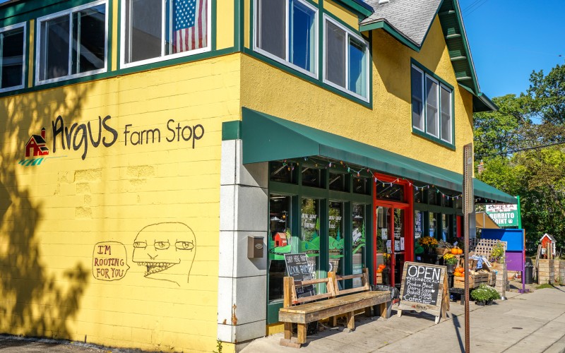 Argus Farm Stop Cafe on Packard. Argus Farm Stop Cafe is a larger yellow building with a welcoming storefront.